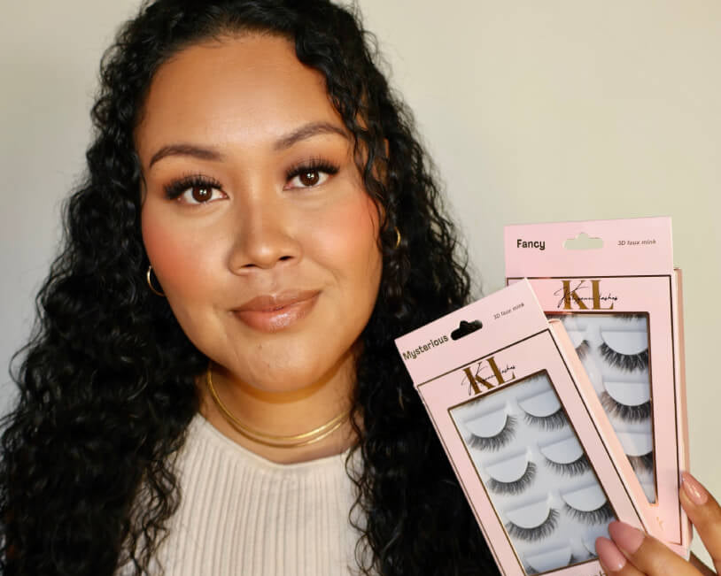 Makeup artist holding Kaliyanei Lashes strip lash packs, showcasing professional lash styles for glam makeup looks.