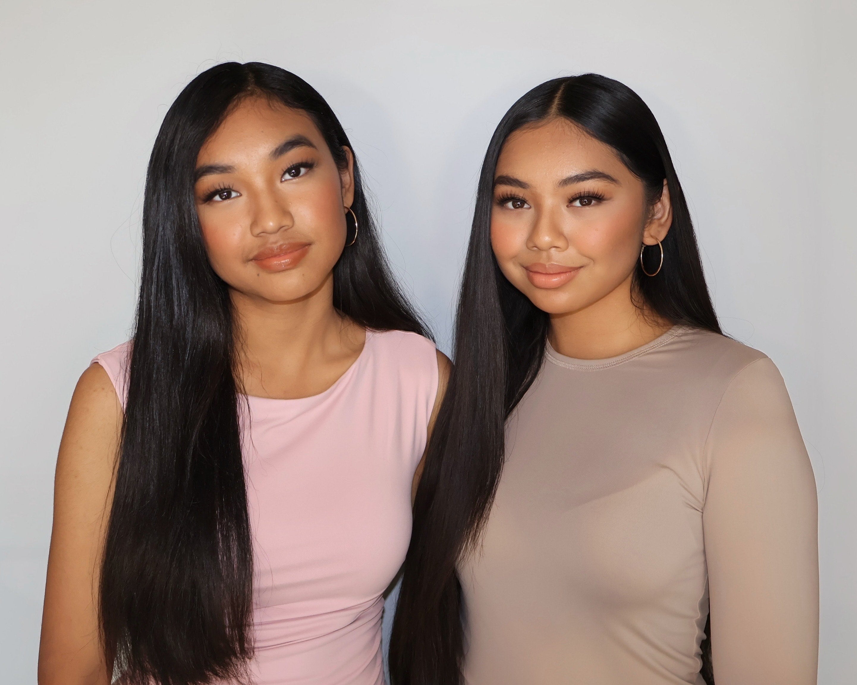 Two women wearing natural makeup and neutral-toned outfits, shown as an example for lash styling inspiration