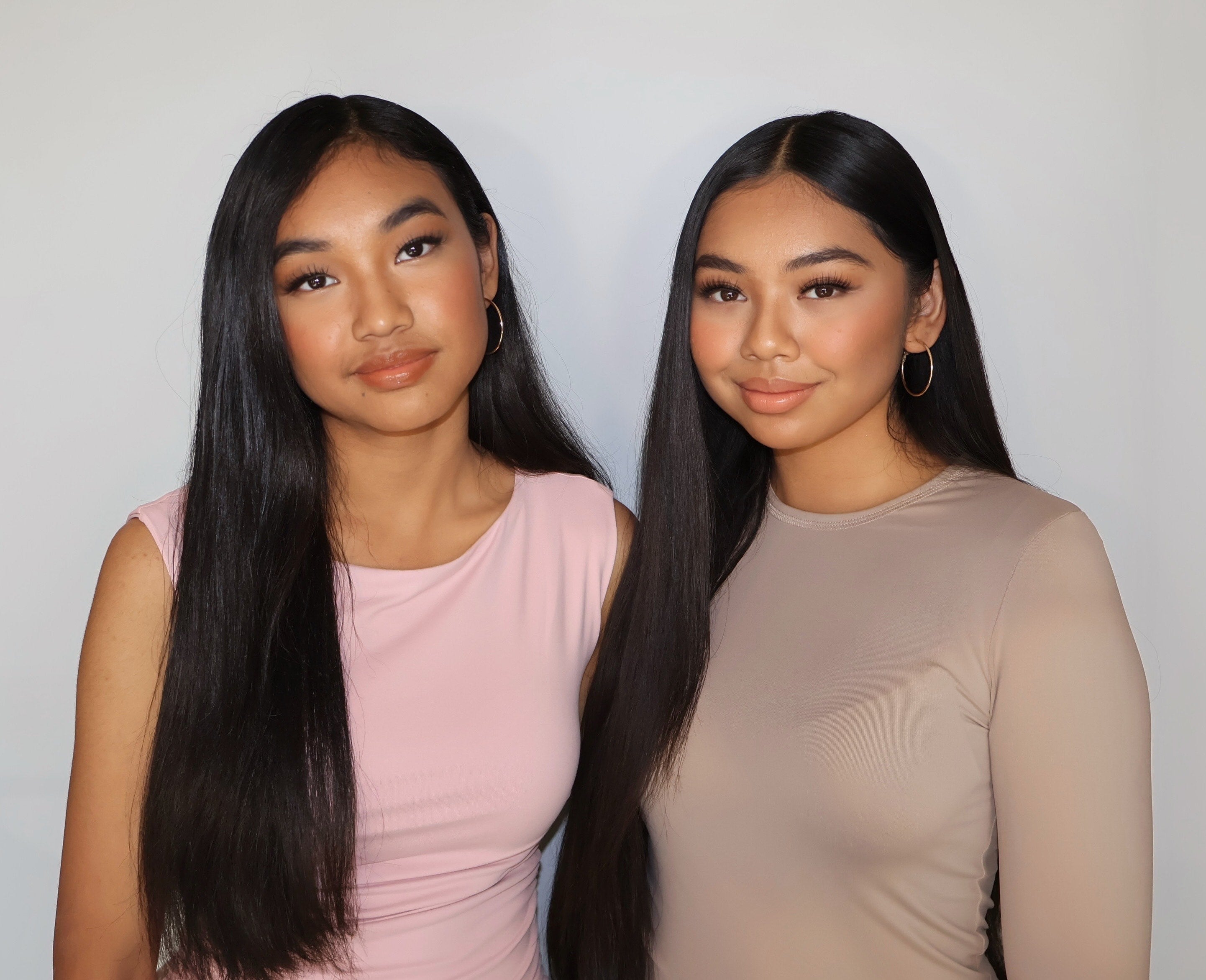 Two women wearing natural makeup and neutral-toned outfits, shown as an example for lash styling inspiration