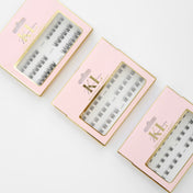 Individual Lashes by Kaliyanei Lashes – Flatlay of Lash Cluster Packs in Pink Packaging on Light Background